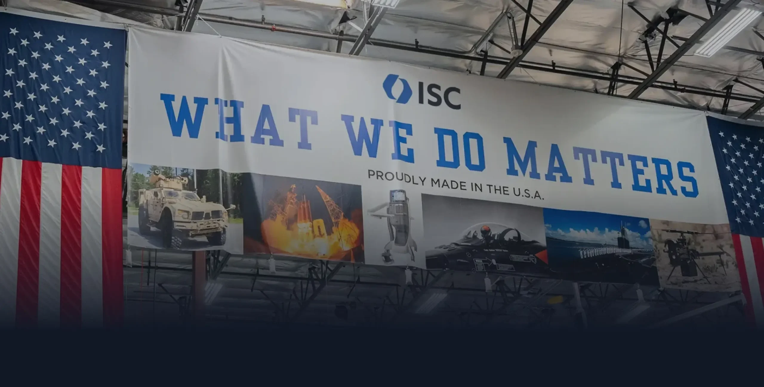 large banner hanging in manufacturing facility with ISC logo and text that says "What We Do Matters". An American flag hangs in the foreground.